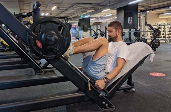 Damien Thompson training on a leg press at Fitness First gym