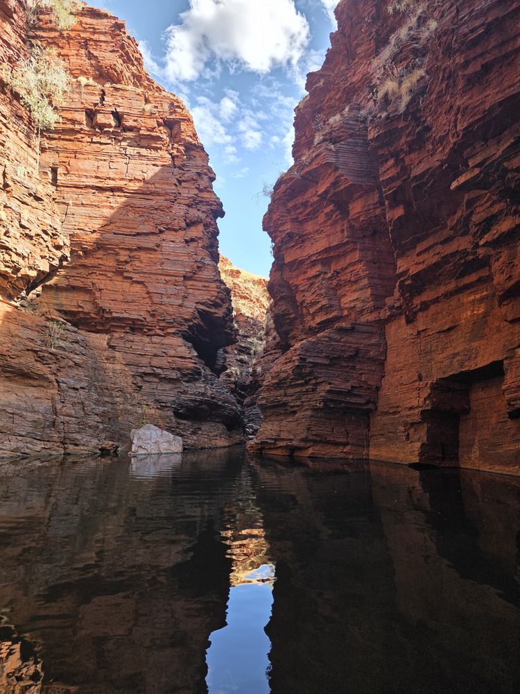 Red gorge walls reflected in a still pool at Karijini National Park